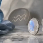 Aquarius July 2026 monthly horoscope with Moonstone as crystal of the month, zodiac symbol ♒