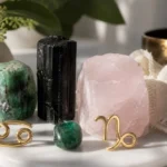 Cancer and Capricorn compatibility with Emerald, Black Tourmaline, and Rose Quartz crystals arranged with zodiac symbols ♋ and ♑