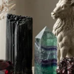 Best crystals for Capricorn: Garnet, Black Tourmaline, Fluorite, Onyx and more arranged with a Capricorn sea goat motif