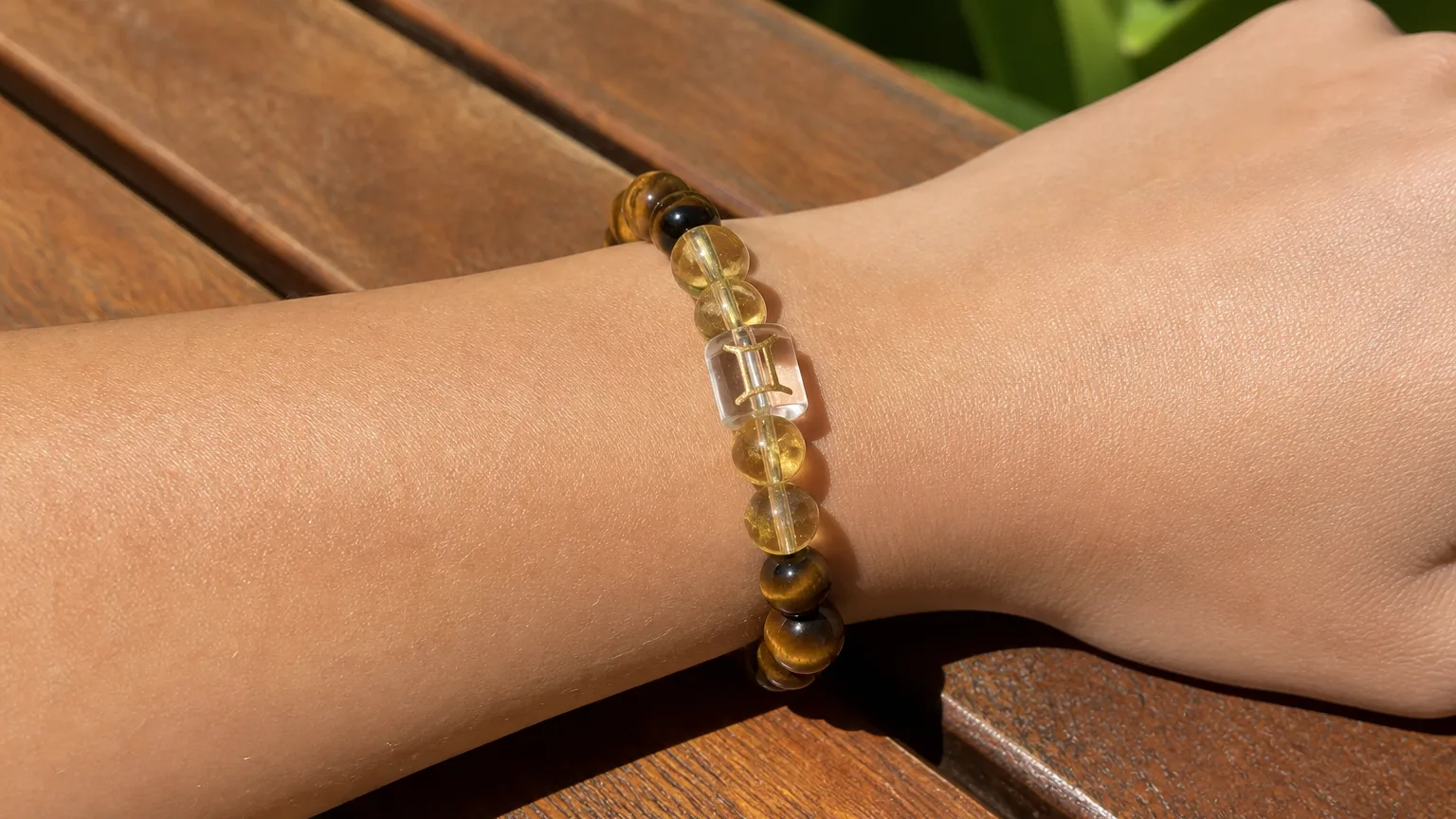 How to use Gemini crystals: a Citrine and Tiger's Eye bracelet on a wooden surface