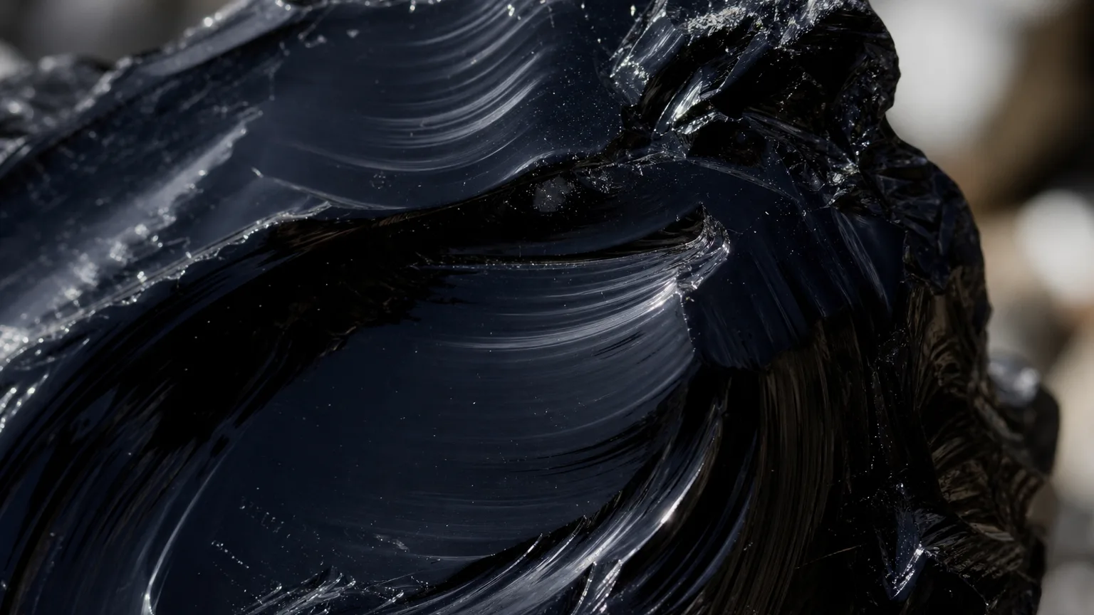 Obsidian Meaning: Healing Properties & Uses 2 Black obsidian volcanic glass mirror surface close-up