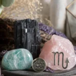 Scorpio and Aquarius compatibility with Black Tourmaline, Amazonite, and Rose Quartz crystals arranged with zodiac symbols ♏ and ♒