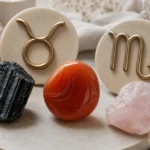 Taurus and Scorpio compatibility with Carnelian, Black Tourmaline, and Rose Quartz crystals arranged with zodiac symbols ♉ and ♏