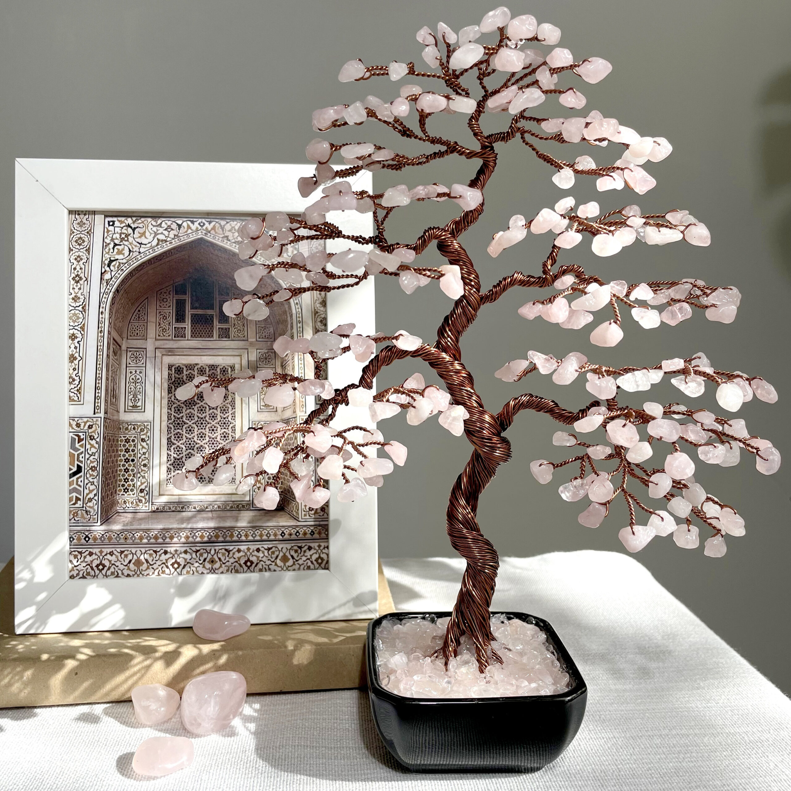 Handmade Rose Quartz Bonsai Tree - Image 1 May include: A pink rose quartz wire wrapped tree with copper wire branches. The tree is in a black pot with a base of pink rose quartz crystals.