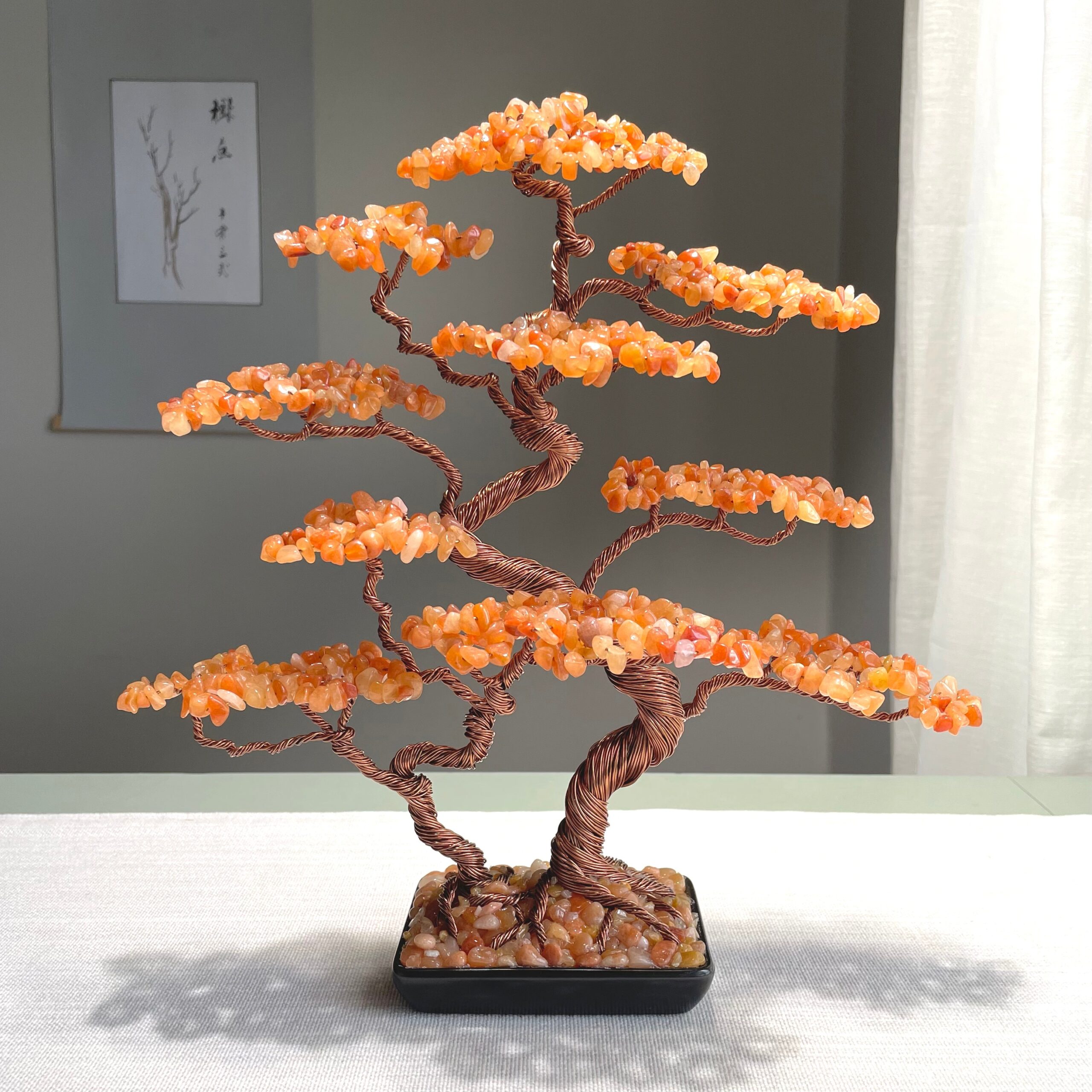 Large Natural Red Aventurine Bonsai Tree (Copper Wire) - Image 1 May include: A decorative bonsai tree sculpture. The tree features a twisted copper wire trunk and branches, adorned with orange-colored gemstone leaves. The tree sits in a black rectangular pot filled with small stones. The sculpture is a unique home decor item.
