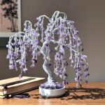 May include: A purple amethyst wire wrapped willow tree with a white base. The tree is decorated with amethyst crystals and is a popular Feng Shui decor item.