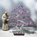 May include: A purple amethyst wire wrapped tree sculpture with a black base. The tree is made of wire and amethyst stones. The tree is about 12 inches tall.