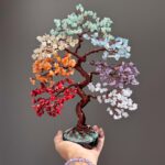 May include: A decorative tree sculpture featuring a twisted dark brown wire trunk and branches adorned with clusters of multi-colored gemstone chips in shades of red, orange, yellow, light green, light blue, purple, and white, set in a black base.